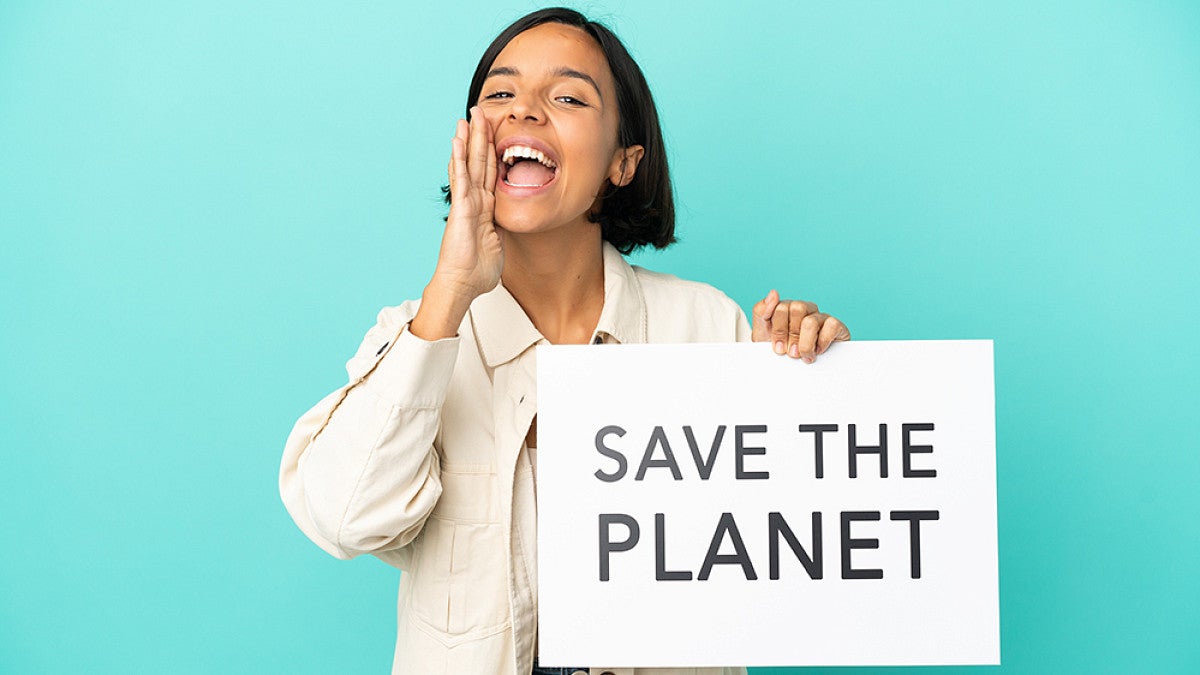 Person holding a sign with "Save the planet" written on it